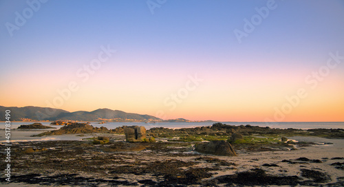 Atardecer dorado en la playa de Caldebarcos con vista de fondo de la población de Carnota, provincia de A Coruña, Galicia, España. photo
