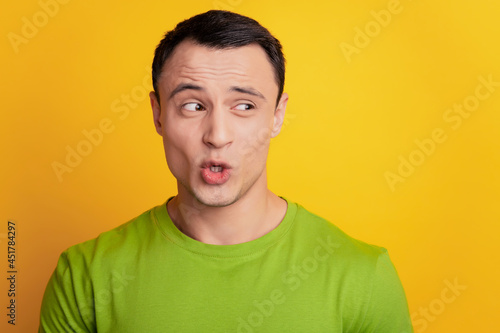 Portrait of curious excited man look empty space open mouth on yellow background © Tetiana