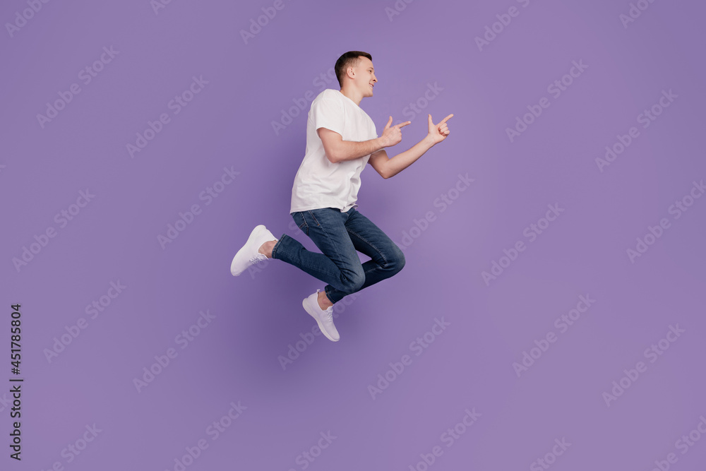 Profile photo of positive crazy adviser guy jump indicate fingers empty space on purple wall Profile photo of positive crazy adviser guy jump indicate fingers empty space on purple wall