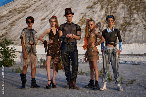 three guys and two girls in fantasy cosplay clothes on a post-capitalist background