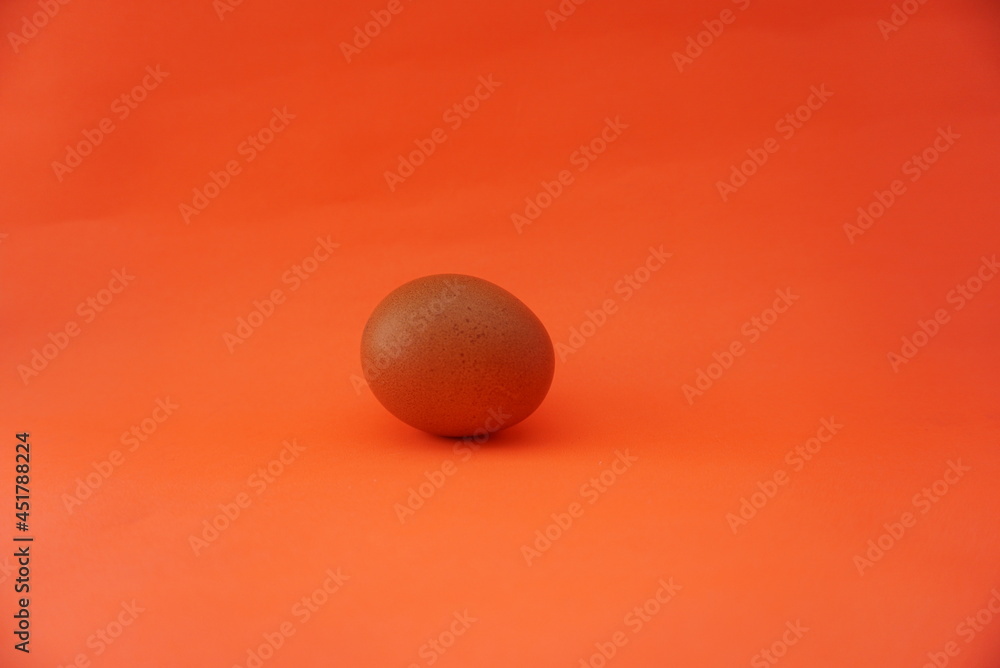 Three chicken eggs from a female hen isolated on an orange background. High protein foods. Suitable for egg business, food, website, health