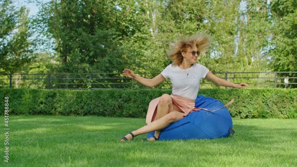 a young woman is enjoying a wonderful cool place in hot summer, having fun, falling on an ottoman, jumping, laughing, running on the green grass. a young woman is enjoying a wonderful cool place in hot summer, having fun, falling on an ottoman, jumping, laughing, running on the green grass.