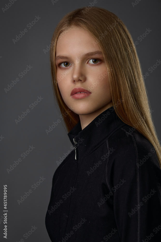 Fototapeta premium Portrait of a young blonde girl in black clothes 