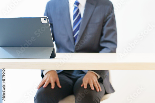 緊張した表情でオンライン面接・会議・打ち合わせに臨むスーツ姿の男性 photo