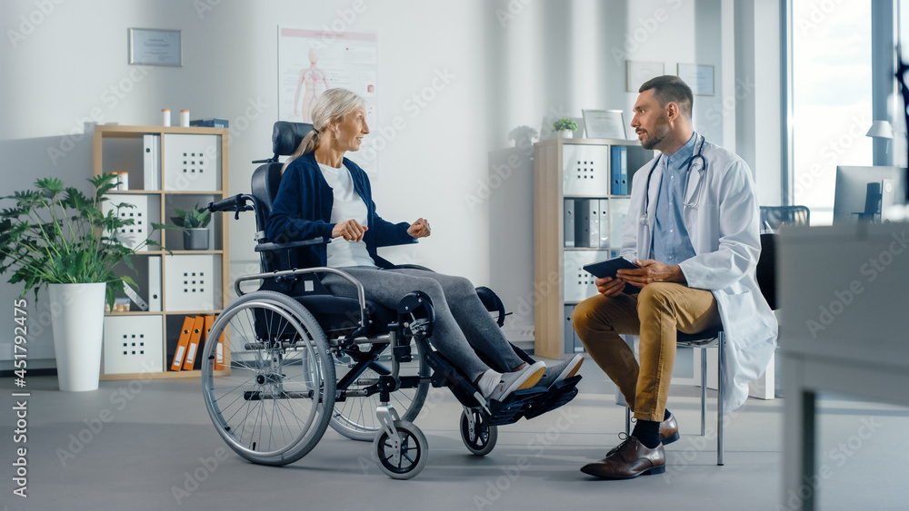 Hospital Physical Therapy: Strong Senior Female in Wheelchair, Talks to a Friendly Rehabilitation Physiotherapist Doctors Gives Advice, Plans Rehabilitation Treatment for Determined Disabled Patient