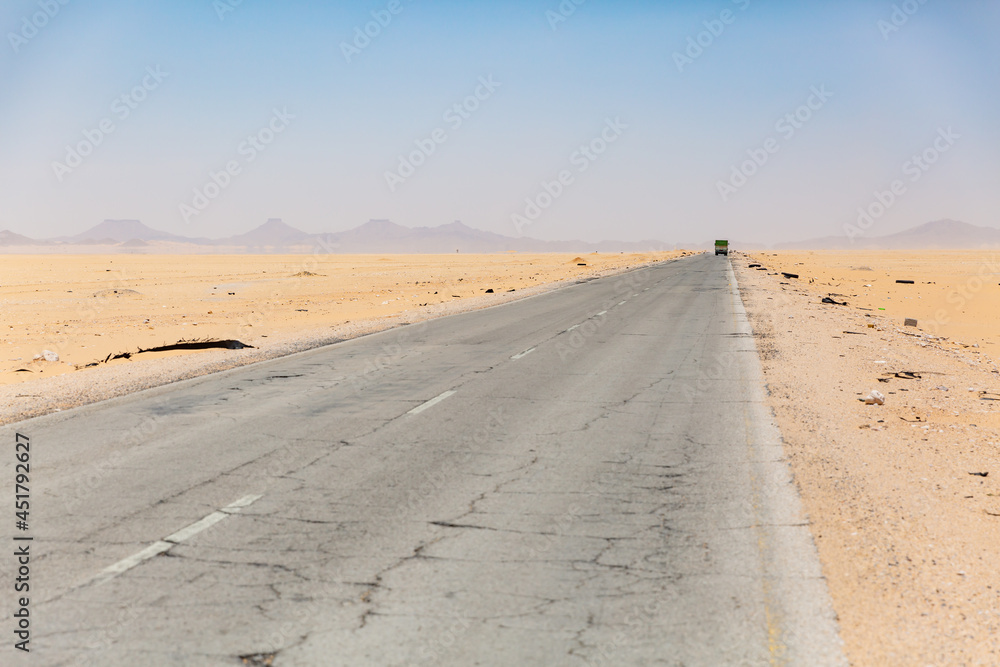 long straight empty road surrounded by desert in hadramaut, yemen