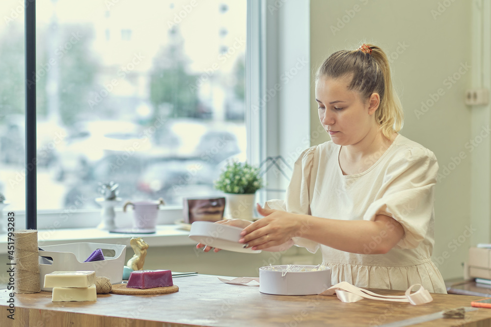 woman entrepreneur packs the order in a beautiful box, perfect service for customers. woman entrepreneur packs the order in a beautiful box, perfect service for customers.