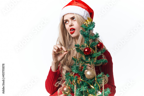 woman wearing santa hat christmas tree decoration holiday light background