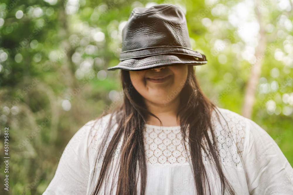 Portrait of trisomy adult outside having fun with hat