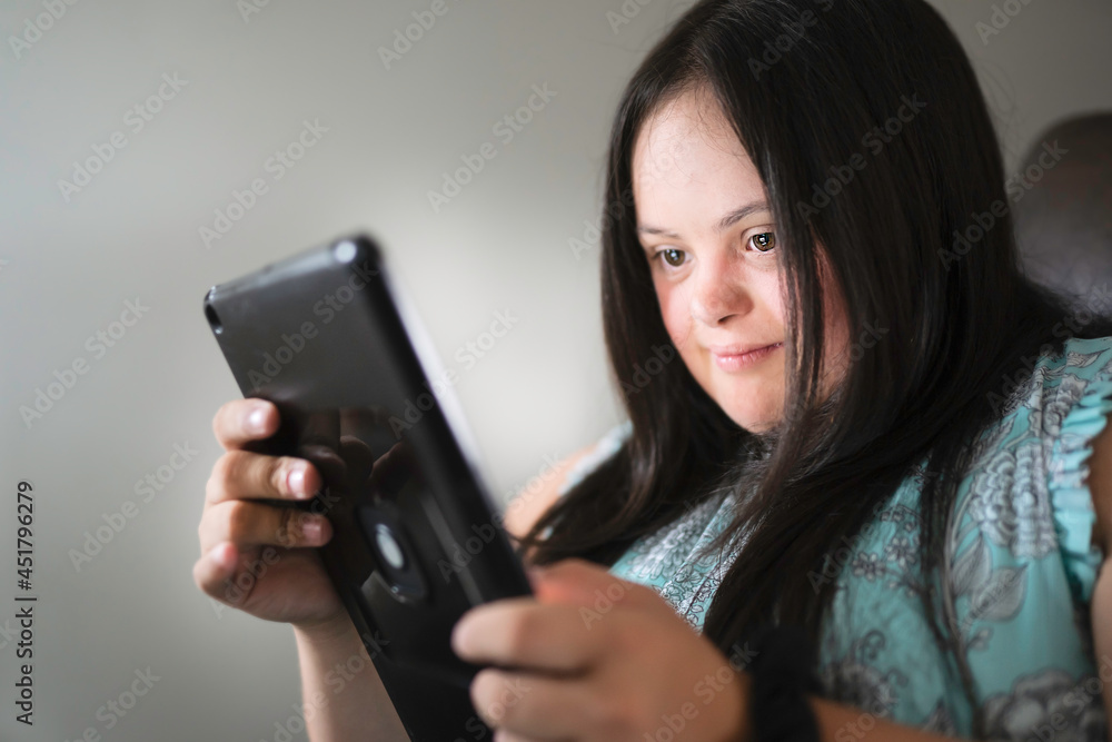 Portrait of trisomy 21 adult working on tablet Portrait of trisomy 21 adult working on tablet