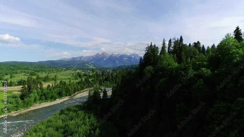 Aerial view of mountain river flowing in the green valley. Beautiful high mountains and green meadows in the summer. Epic cinematic footage in 4K Aerial view of mountain river flowing in the green valley. Beautiful high mountains and green meadows in the summer. Epic cinematic footage in 4K