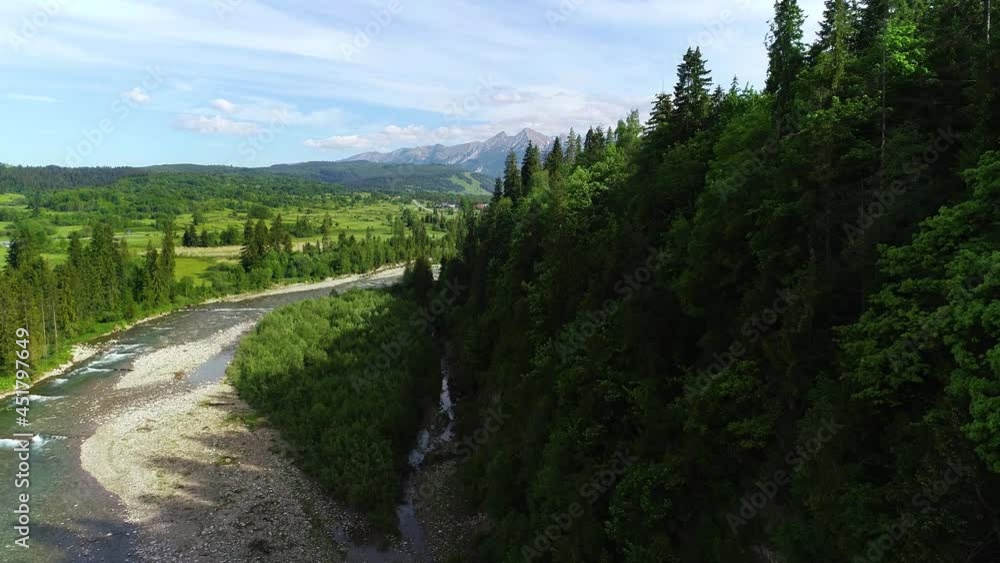 Aerial view of mountain river flowing in the green valley. Beautiful high mountains with brook and green meadows in the summer. Epic cinematic footage in 4K Aerial view of mountain river flowing in the green valley. Beautiful high mountains with brook and green meadows in the summer. Epic cinematic footage in 4K