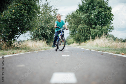 Young boy rides a bicycle on a bicycle path.