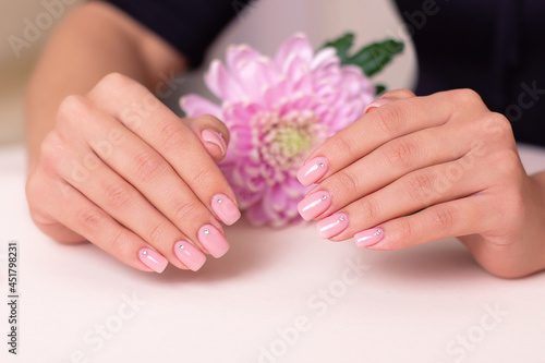 Beautiful female hands with wedding manicure nails  pink gel polish  peony flower