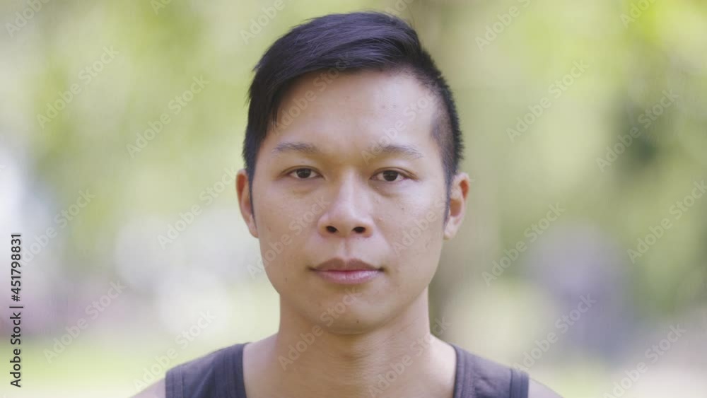 Portrait of handsome Asian male looking to camera and smiling Portrait of handsome Asian male looking to camera and smiling