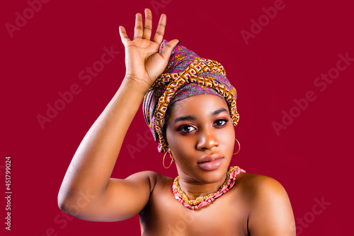 zanzibar woman with headwear in red studio wall background