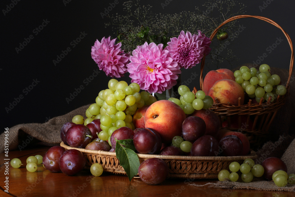 Still life with fruits and a bouquet of summer flowers on a dark background Still life with fruits and a bouquet of summer flowers on a dark background