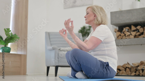 Old Woman doing Meditation on Mat at Home