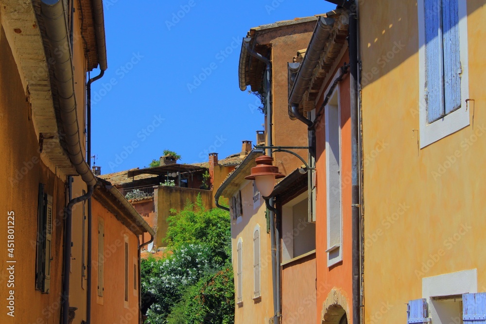 A popular tourist holiday destination, beautiful French village in Provence called Roussillon with its ancient houses and buildings, old ochre-colored roofs and walls, and relaxed summer vibes.