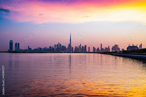 Stunning view of Dubai city skyline at sunset with a colorful sky and reflection on the water. Al Jaddaf, Dubai, UAE.