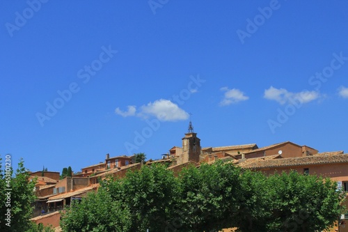 A popular tourist holiday destination  beautiful French village in Provence called Roussillon with its ancient houses and buildings  old ochre-colored roofs and walls  and relaxed summer vibes.