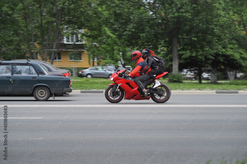 Motorcyclists in special clothes and protective helmets on the goal ride on the city highway. on a red motorcycle. High Motorcyclists in special clothes and protective helmets on the goal ride on the city highway. on a red motorcycle. High