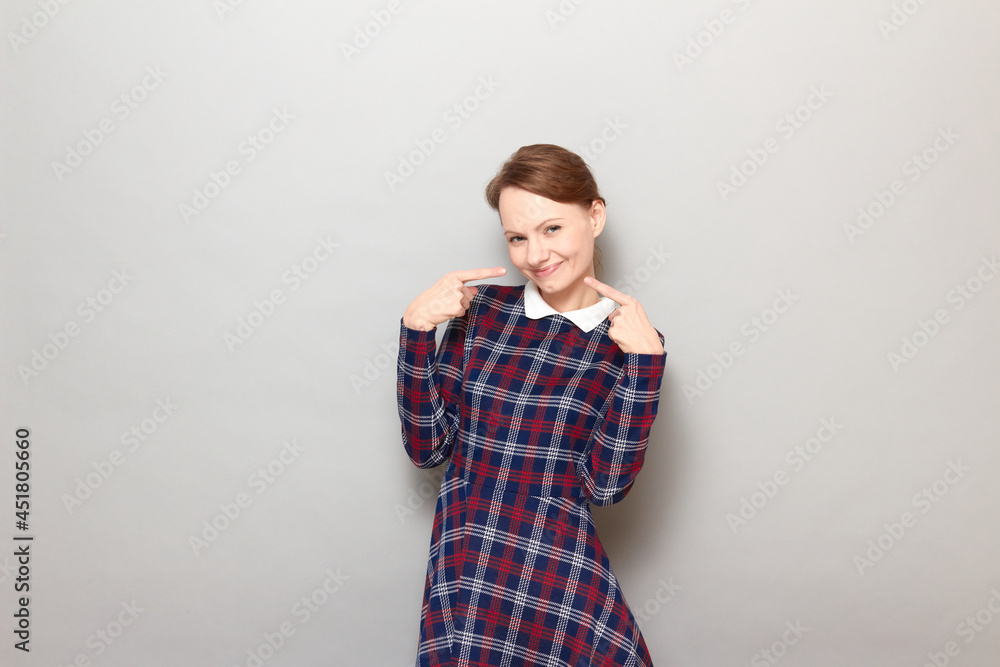 Portrait of happy girl pointing with fingers at her cheerful smile Portrait of happy girl pointing with fingers at her cheerful smile