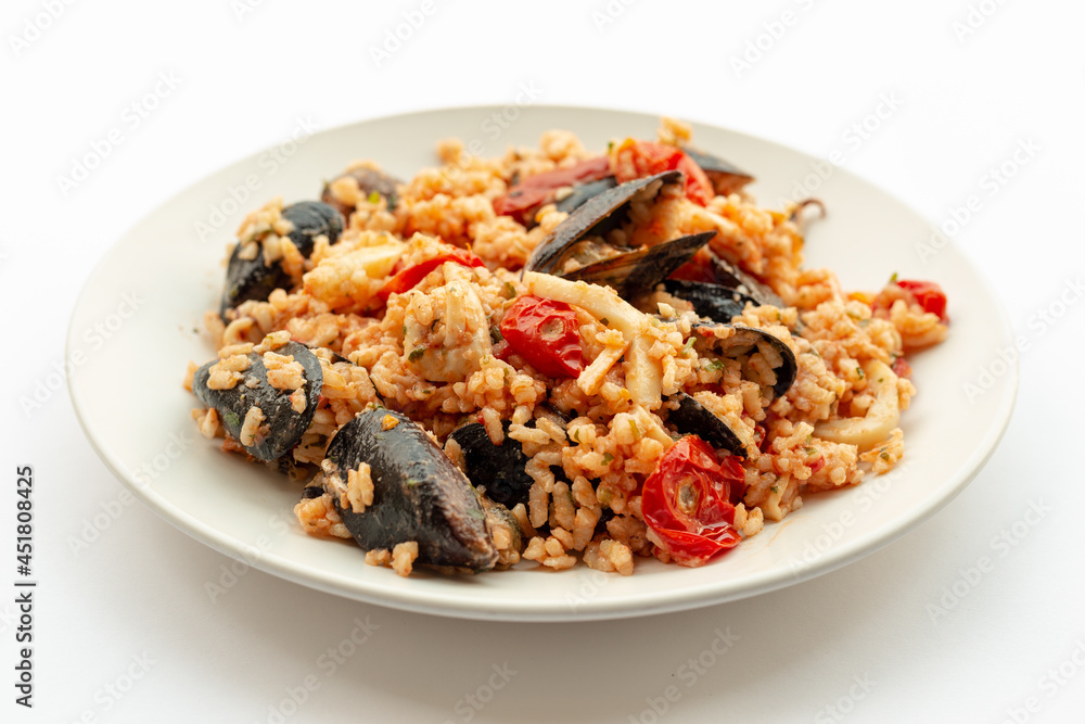 Seafood rice, typical Italian food. Served on a white background. Seafood rice, typical Italian food. Served on a white background.