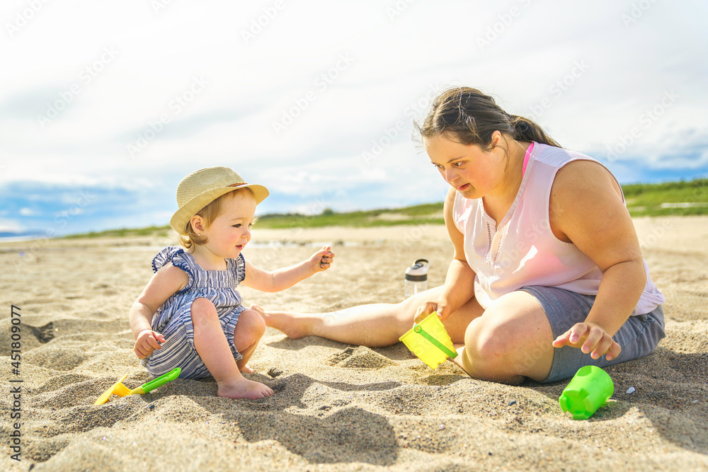 Portrait of trisomy adult outside having fun with baby Portrait of trisomy adult outside having fun with baby