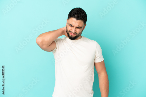 Young arab man isolated on blue background with neckache