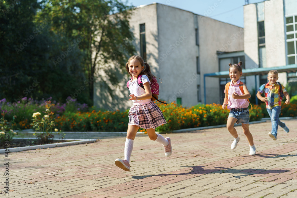 © skif - group of school children with backpacks run out of school, after the end of classes. Classmates, school friends. The beginning of holidays. The end of quarantine. Back to school. © skif - group of school children with backpacks run out of school, after the end of classes. Classmates, school friends. The beginning of holidays. The end of quarantine. Back to school.