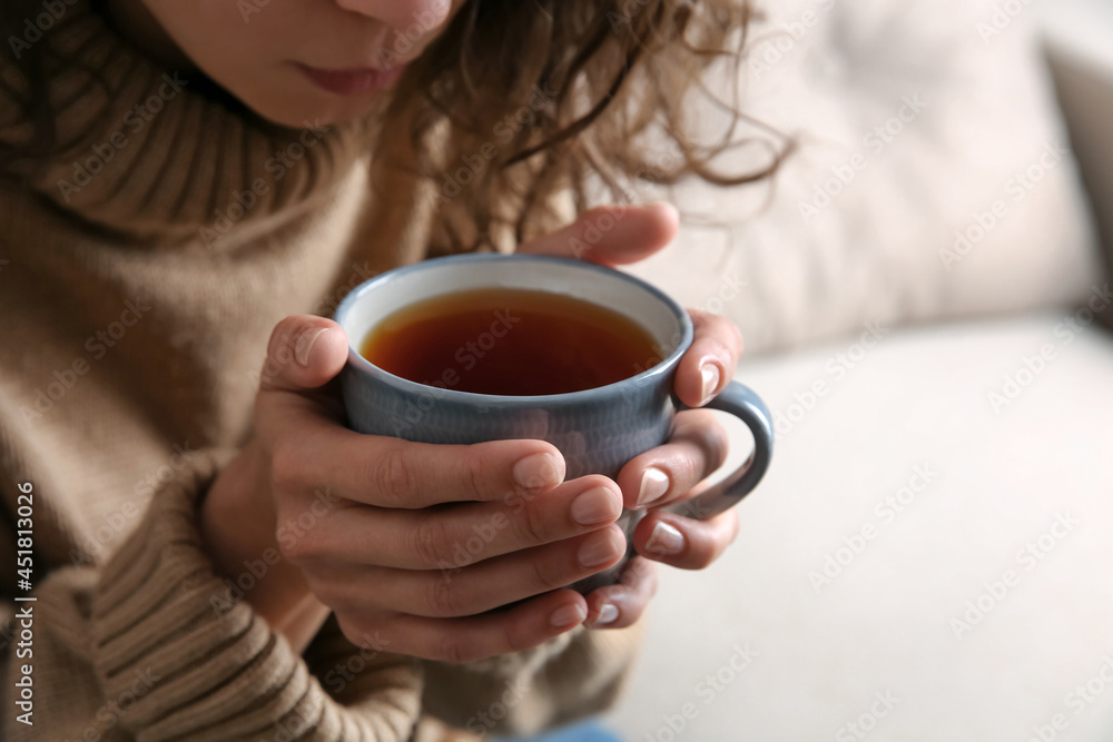 Woman with cup of hot tea indoors, closeup. Cozy home atmosphere Woman with cup of hot tea indoors, closeup. Cozy home atmosphere