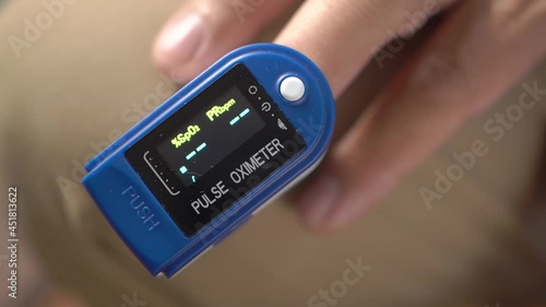 Close-up of a man using a pulse oximeter to measure oxygen saturation and heart rate, a man using a pulse oximeter to measure oxygen saturation in pandemic covid19, medical surveillance at home