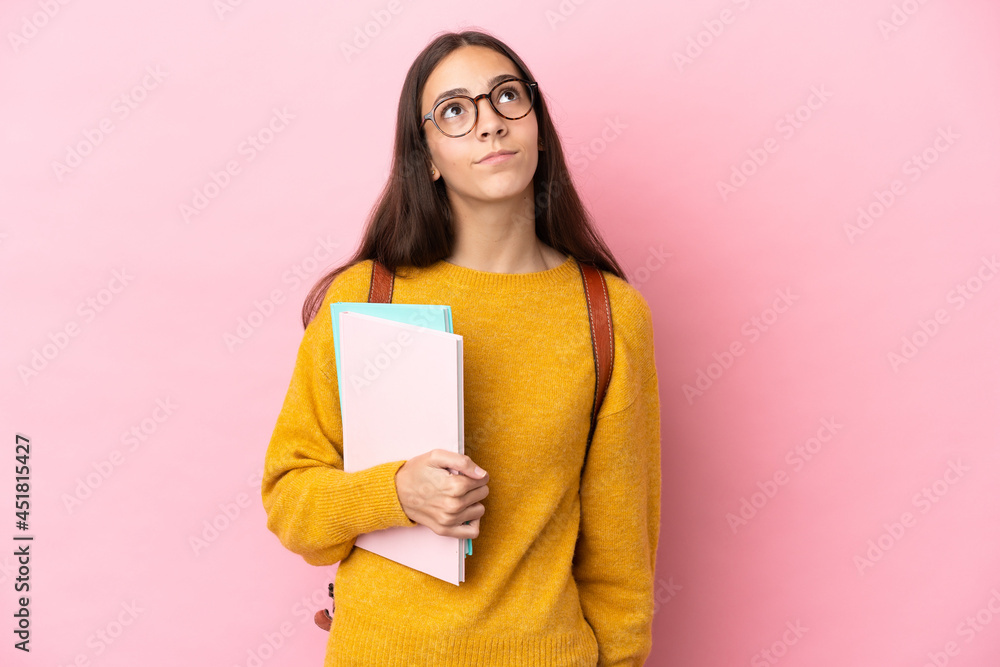 Young student woman over isolated background and looking up Young student woman over isolated background and looking up