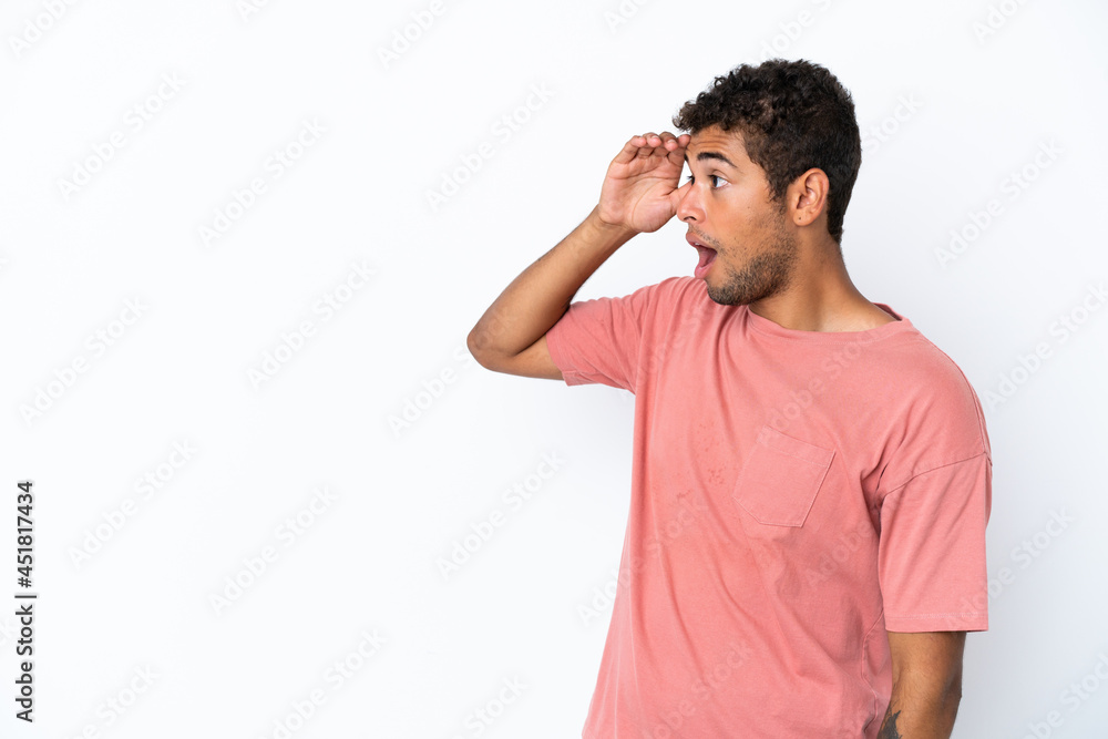 Young handsome Brazilian man isolated on white background with surprise expression while looking side Young handsome Brazilian man isolated on white background with surprise expression while looking side