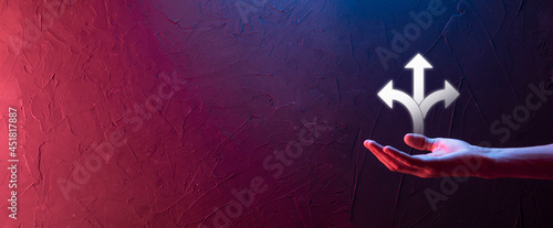 Businessman in a suit holds a sign showing three directions. in doubt, having to choose between three different choices indicated by arrows pointing in opposite direction concept. three ways to choose