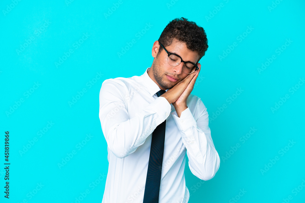 Young business Brazilian man isolated on blue background making sleep gesture in dorable expression Young business Brazilian man isolated on blue background making sleep gesture in dorable expression