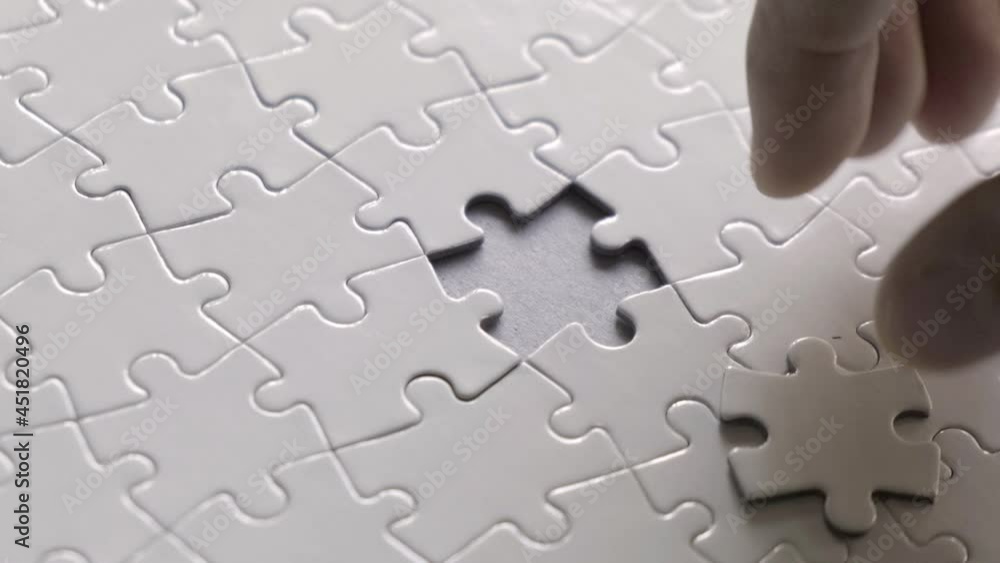 Man finishing completely blank, white jigsaw puzzle. 4k, 50fps footage. Man finishing completely blank, white jigsaw puzzle. 4k, 50fps footage.