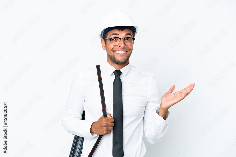 Architect brazilian man with helmet and holding blueprints with shocked facial expression