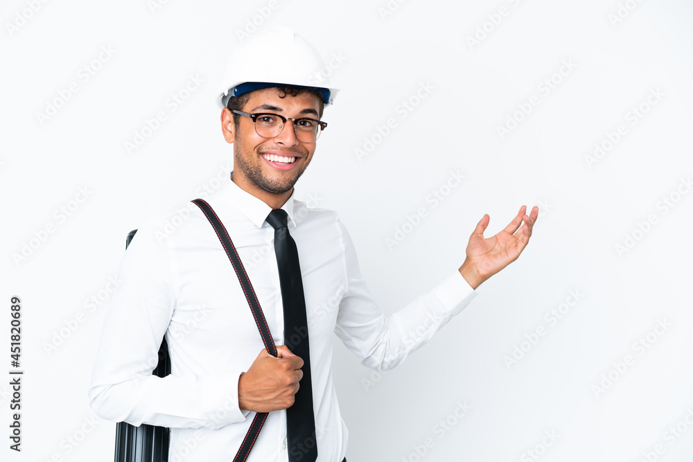 Architect brazilian man with helmet and holding blueprints extending hands to the side for inviting to come Architect brazilian man with helmet and holding blueprints extending hands to the side for inviting to come
