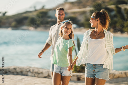 Family Walking Near The Sea And Enjoying Summer Vacation