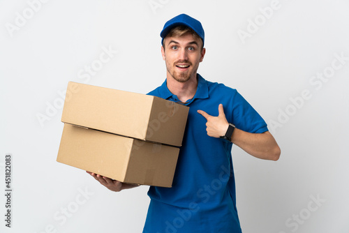 Young delivery blonde man isolated on white background with surprise facial expression © luismolinero