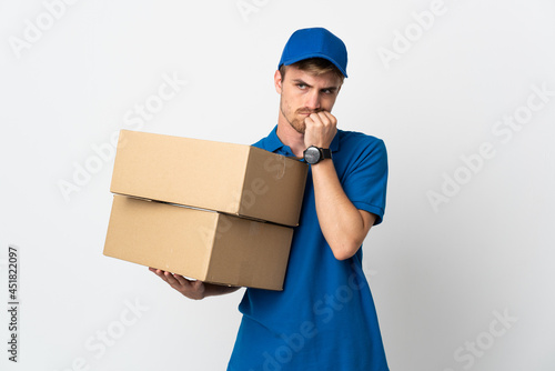 Young delivery blonde man isolated on white background having doubts