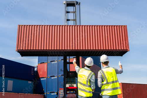 Engineers are overseeing the transportation of cargo with containers inside the warehouse. Container in export and import business and logistics. photo