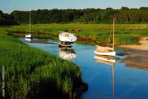 Several boats appear stranded in a creek at low tide photo