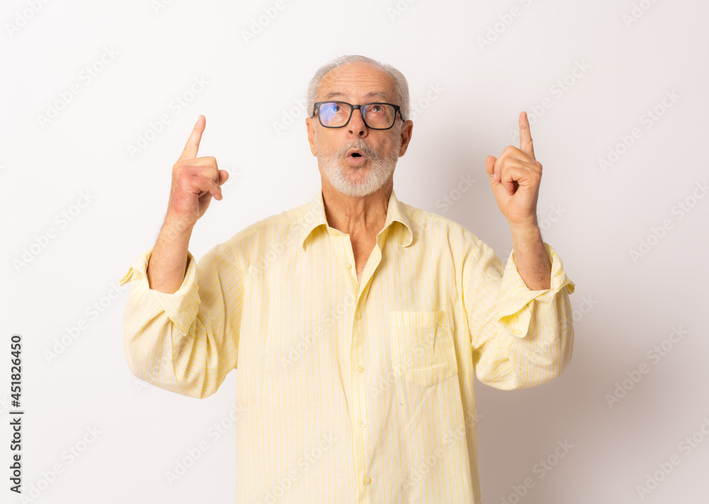 Senior surprised man pointing fingers up over white background. Senior surprised man pointing fingers up over white background.