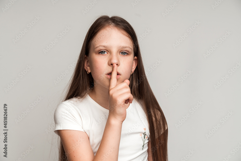 Shh, be quiet! Portrait of funny cute little girl making silence gesture with finger on her lips, keeping some secret, child mystery. Studio shot isolated on white background Shh, be quiet! Portrait of funny cute little girl making silence gesture with finger on her lips, keeping some secret, child mystery. Studio shot isolated on white background