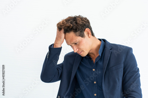 Anxious handsome businessman puts his hand to his head, confused and serious about the problem. 