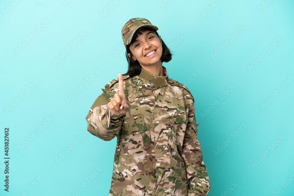Fototapeta premium Military mixed race woman isolated on blue background showing and lifting a finger