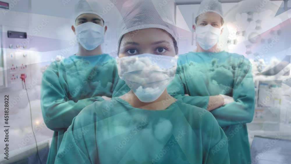 Animation of uk flag over group of doctors wearing face masks Animation of uk flag over group of doctors wearing face masks